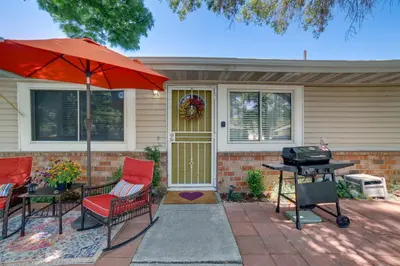 a patio with chairs and an umbrella and a grill at 1 Mi to Reno-Sparks Family Retreat with Fireplace! in Reno