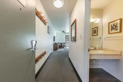 a hallway with a bathroom with a sink and a mirror at 135 Bldg C condo in Truckee