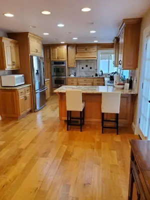 a kitchen with wooden cabinets and a kitchen island with chairs at Grass Valley Oasis - Spacious Family Retreat Near Rollins Lake in Grass Valley