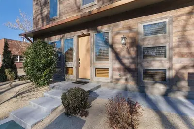 a house with a wooden door and stairs in front at Reno Basecamp 2 King Suites, Walk to Food and Fun in Reno