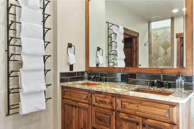 a bathroom with a sink and a mirror and towels at Reno Basecamp 2 King Suites, Walk to Food and Fun in Reno