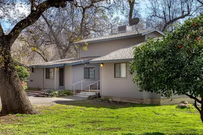 a house with a tree in front of it at Grand Riverside Retreat - Private Walkway to the River in Three Rivers