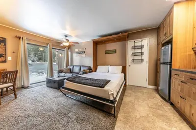 a bedroom with a bed and a couch and a kitchen at 132 Bldg C condo in Truckee