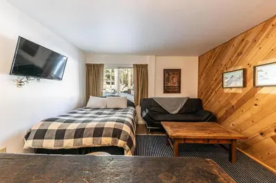 a hotel room with a bed and a couch and a tv at 112 Bldg B condo in Truckee