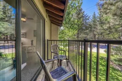 a balcony with two chairs and a window with a view at 211 Bldg B condo in Truckee