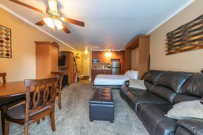 a living room with a leather couch and a bedroom at Cozy Deluxe Studio #131 at Donner Lake Village condo in Truckee