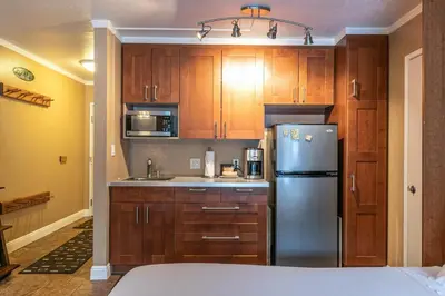 a kitchen with wooden cabinets and a stainless steel refrigerator at Cozy Deluxe Studio #131 at Donner Lake Village condo in Truckee