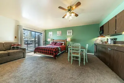 a bedroom with a bed and a table and a kitchen at 224 Bldg B condo in Truckee