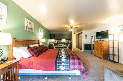 a bedroom with a large bed and a kitchen at 224 Bldg B condo in Truckee