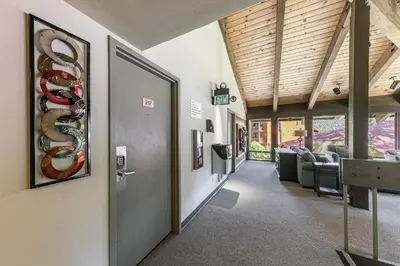 a hallway in a building with a door and chairs at 217 Bldg B condo in Truckee