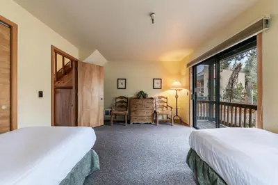 a bedroom with two beds and a balcony at 154 Bldg D townhouse in Truckee