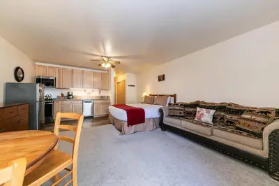 a large bedroom with a bed and a kitchen at 213 Bldg B condo in Truckee