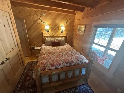 a bedroom with a bed in a wooden cabin at Apple Valley Cabin in Sonora