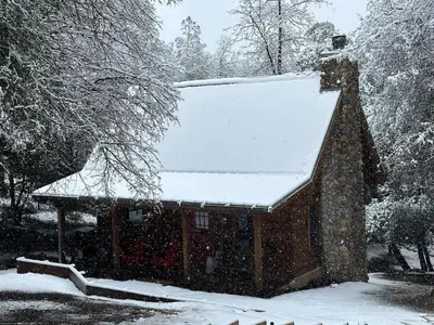 a snow covered cabin with a snow covered roof at Apple Valley Cabin in Sonora