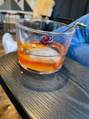 a glass of drink on a table with a spoon at Cozy Cabin - Hot Tub, Fire Pit, & Pets in Arnold