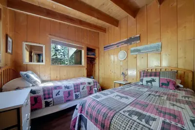 a bedroom with two beds in a wooden cabin at Kit Carson Lodge in Kit Carson