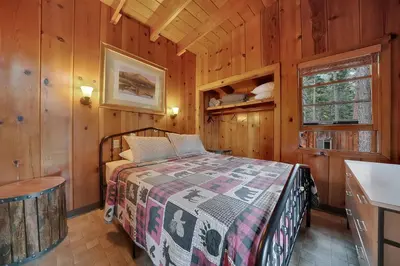 a bedroom with a bed in a wooden cabin at Kit Carson Lodge in Kit Carson