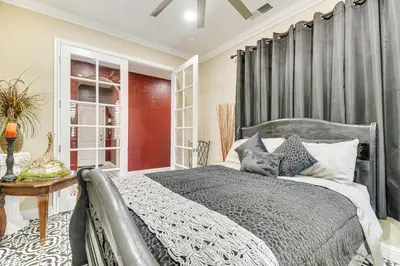 a bedroom with a gray bed and a table at Golf, Fish and More Cozy Safari Unit in Atwater! in Atwater
