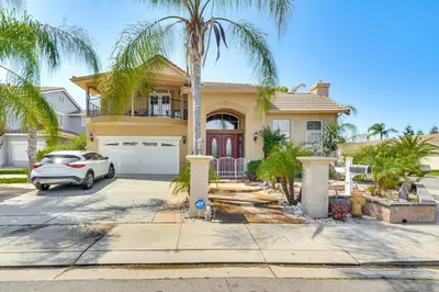 a house with a palm tree in front of it at Golf, Fish and More Cozy Safari Unit in Atwater! in Atwater