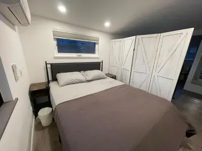 a bedroom with a bed with white cabinets and a window at Kaweah River Cabin - Pool, Hot Tub, Movie Projector in Three Rivers