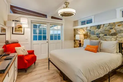 a bedroom with a large bed and a red chair at Kaweah River Cabin - Pool, Hot Tub, Movie Projector in Three Rivers