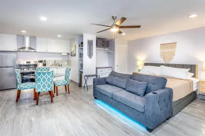 a bedroom with a bed and a couch and a kitchen at Tranquil Riverfront Studio in Three Rivers