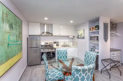 a kitchen with a glass table and blue chairs at Tranquil Riverfront Studio in Three Rivers