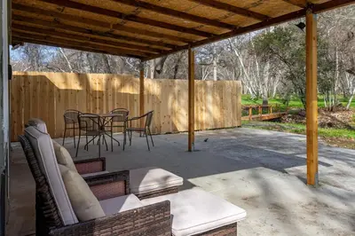 a patio with chairs and tables and a fence at Tranquil Riverfront Studio in Three Rivers