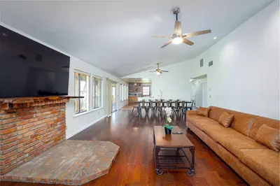 a living room with a couch and a brick fireplace at Serene Riverfront Home - 150 yds from the River in Three Rivers