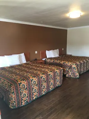 two beds in a hotel room with two bedsskirtspectspectssenalsenalsenalsenal at colfax motorlodge in Colfax