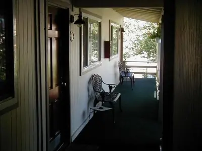 a porch with two chairs and a table and a window at colfax motorlodge in Colfax