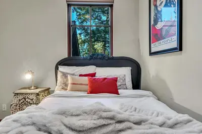 a bedroom with a bed with red pillows and a window at Star Haven Game Room & Forest Views in Truckee