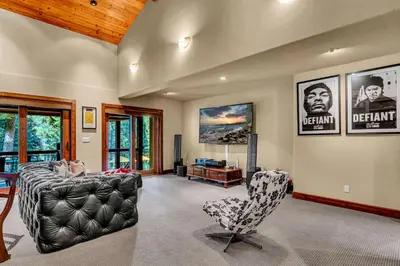 a man laying on a couch in a living room at Star Haven Game Room & Forest Views in Truckee