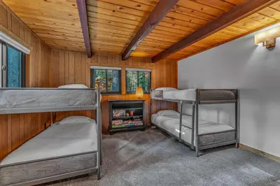 two bunk beds in a room with wooden ceilings at Laid-Back Tahoe Stay Walk to Lake & EV Charger in Homewood