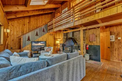 a living room with blue couches and a fireplace at Laid-Back Tahoe Stay Walk to Lake & EV Charger in Homewood