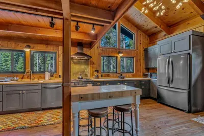 a kitchen withsteel appliances and wooden ceilings and windows at Laid-Back Tahoe Stay Walk to Lake & EV Charger in Homewood