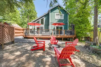 a yard with red chairs and a green house at Hike, Swim and Golf Home Near Dtwn Twain Harte in Twain Harte