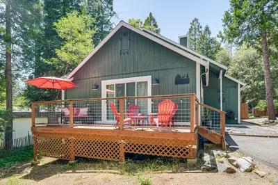 a house with a deck with chairs and an umbrella at Hike, Swim and Golf Home Near Dtwn Twain Harte in Twain Harte