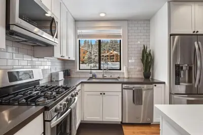 a kitchen with white cabinets and a stove top oven at Northstar 2BR Walk to Village Bike Hike Rec Center in Truckee