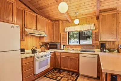 a kitchen with wooden cabinets and a white refrigerator at Serene Tahoe Donner Cabin mins to Lake, Ski, Golf in Truckee
