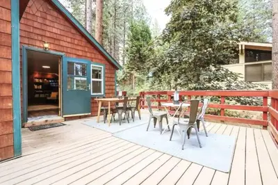 a wooden deck with a table and chairs on it at Charming Kings Beach Cabin, Hot Tub, Walk to Lake in Kings Beach