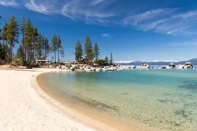 a view of a beach with trees and the water at Charming Kings Beach Cabin, Hot Tub, Walk to Lake in Kings Beach