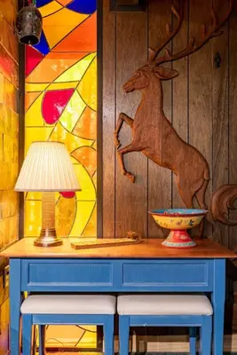 a table with two stools and a lamp and a painting at Walk to Lake West Shore Cabin Hot Tub DogOK EVplug in Homewood