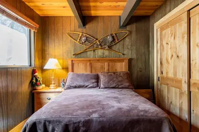 a bedroom with a bed with a butterfly on the wall at Walk to Lake West Shore Cabin Hot Tub DogOK EVplug in Homewood