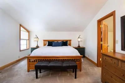a bedroom with a large bed with a black bench at Family Escape Minutes to Northstar EV Charger WandD in Truckee