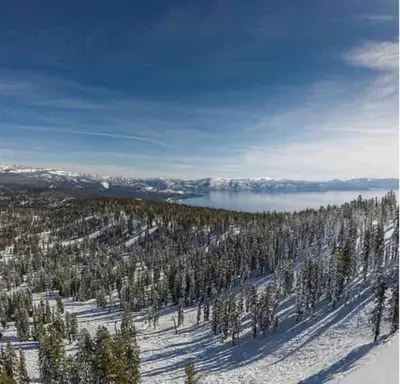 a snow covered hill with trees and a body of water at Family Escape Minutes to Northstar EV Charger WandD in Truckee