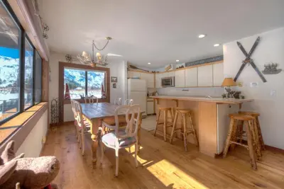 a kitchen and dining room with a table and chairs at Serene Condo by Palisades Base and Golf Course in Olympic Valley