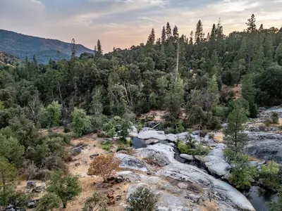an aerial view of a river in a forest at Riverfront Serenity with Stunning Views in Mariposa