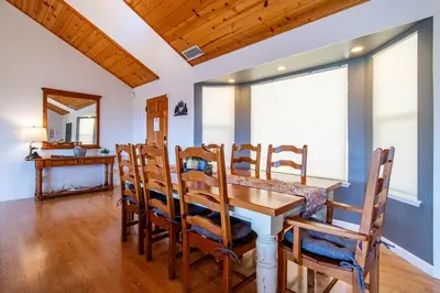 a dining room with a wooden table and chairs at Riverfront Serenity with Stunning Views in Mariposa