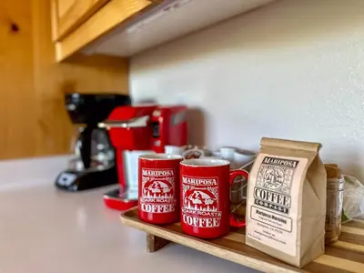 two red coffee mugs sitting on a shelf in a kitchen at Riverfront Serenity with Stunning Views in Mariposa